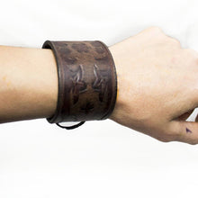 Load image into Gallery viewer, Handmade cuff bracelet, brown leather with vintage look. Hand tooled viking design, Silver eyelets and black kangaroo lace 2 ways of tying to accommodate for different sizes.

